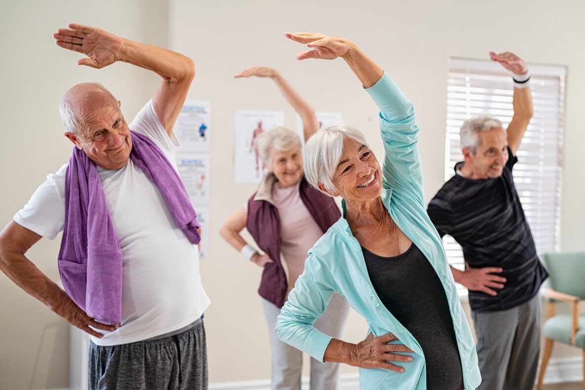 Group of seniors doing stretching exercise together at retiremen